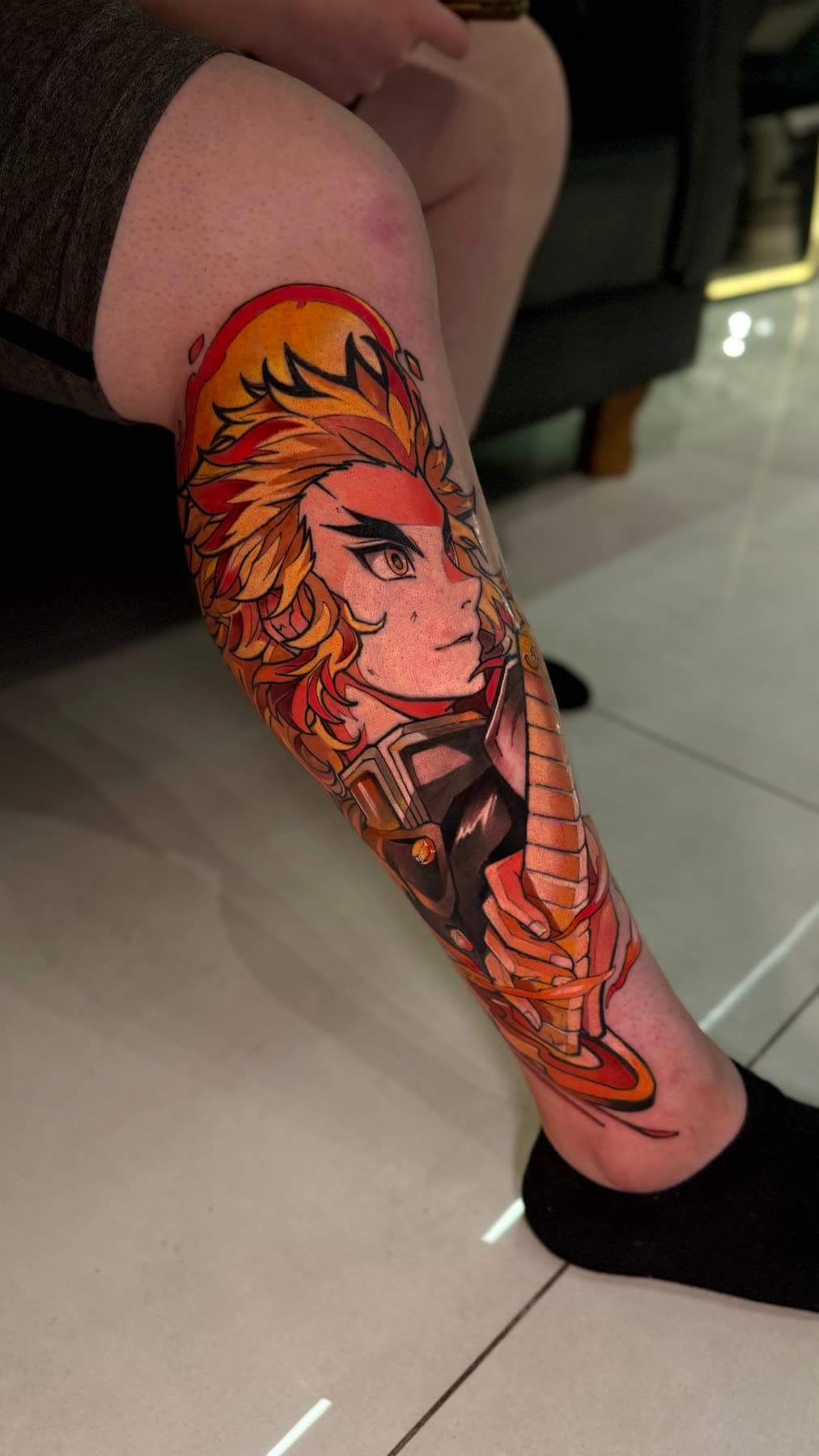 Perna fechada em cor: personagem de anime de cabelo laranja em chamas, com uniforme escuro