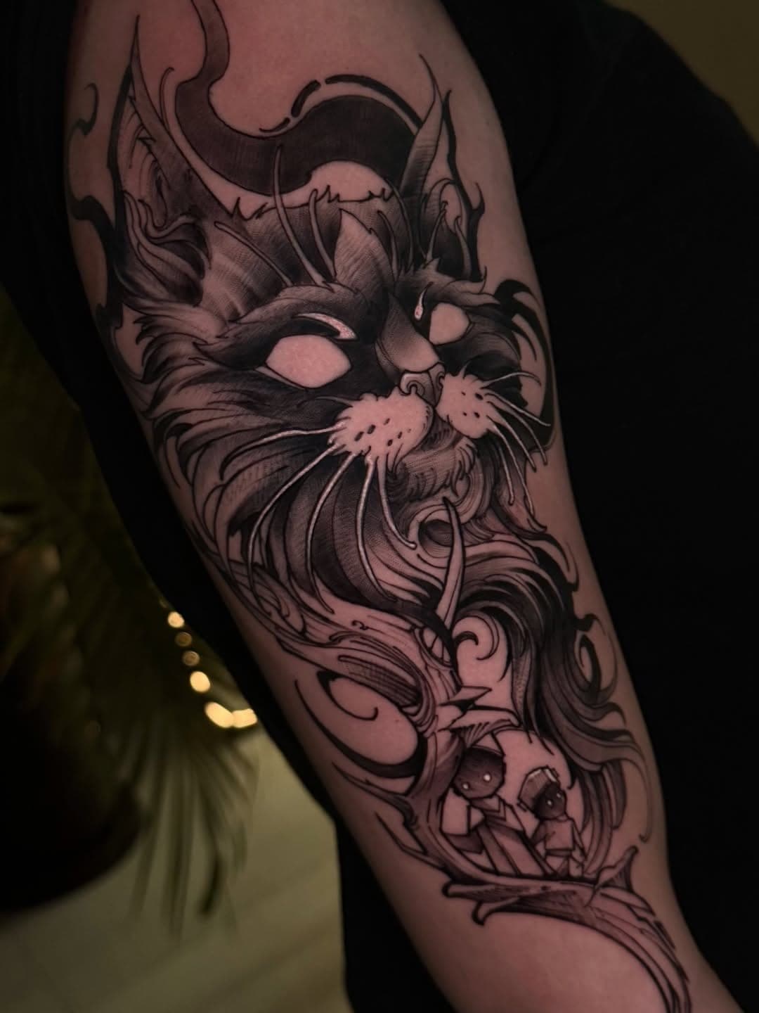 Braço em blackwork ilustrativo: gato de olhos claros com ornamentos